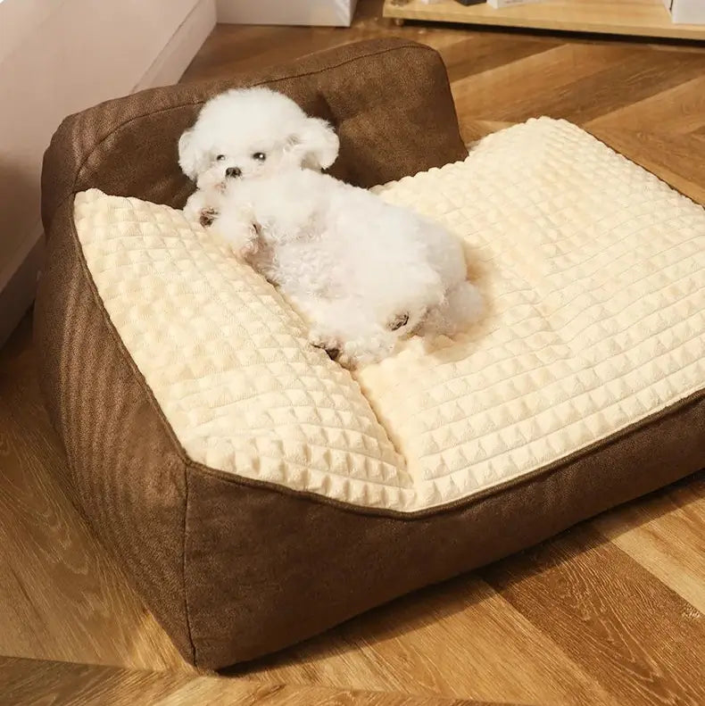 A small dog lying comfortably on a chocolate-coloured L-shape dog bed, highlighting its cosy design and warm colour tone.